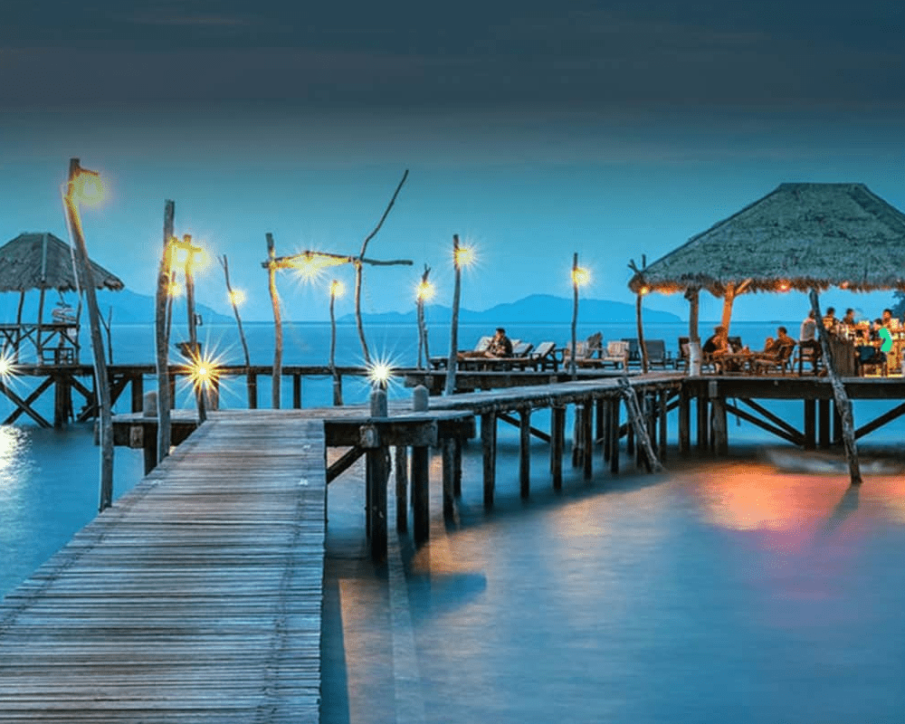 Wooden jetty and beach huts at dusk, Andaman Islands tour package