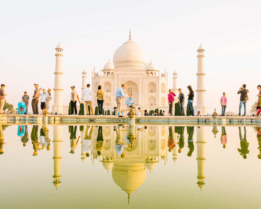 Taj Mahal reflected in water with visitors, Agra