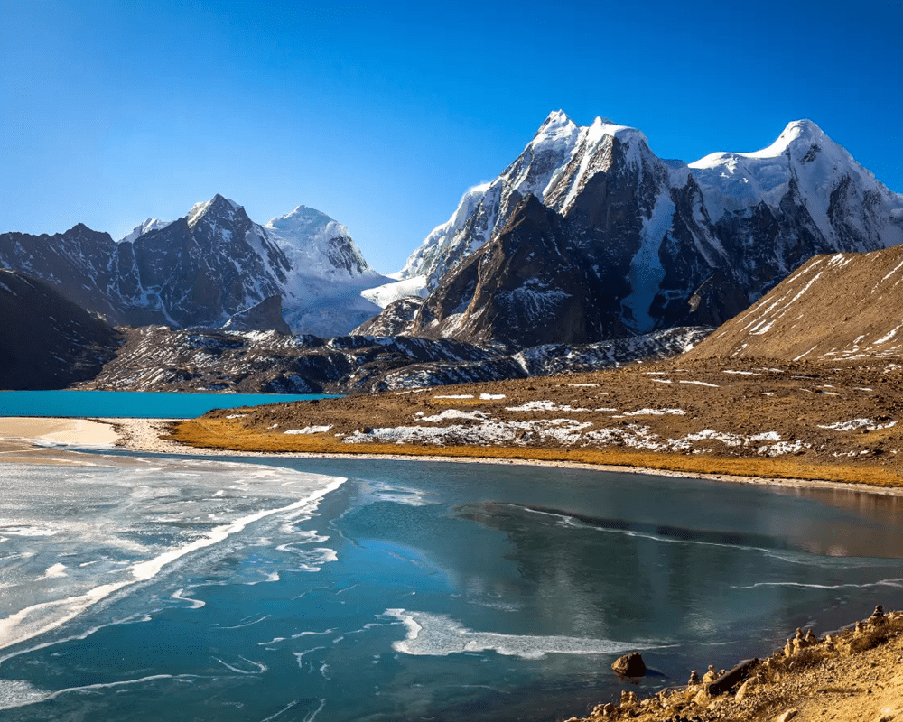 Gurudongmar Lake below snow peaks, North India tour package