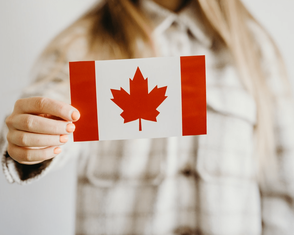 Hand holding the Canadian flag, Canada study and work visa