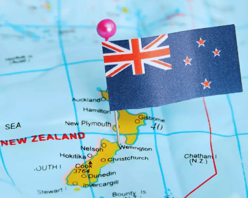 New Zealand flag pinned on a map of New Zealand